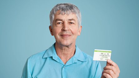 happy older man holding Utah medical marijuana card